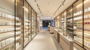 Intérieur de boutique moderne avec vitrines en verre, présentoirs produits et éclairage soigné créant un parcours client fluide.